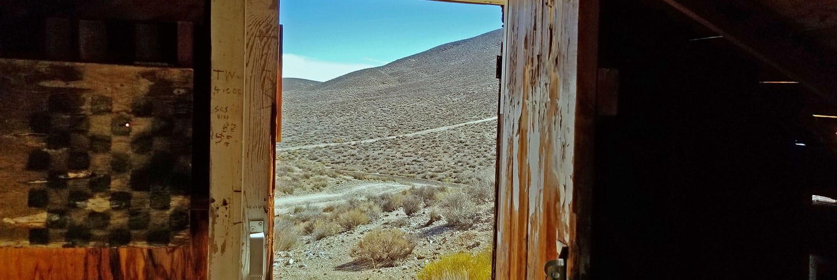 View Out the Front Door. Window Shutter Was Chessboard Tabletop Scavenged from Skidoo | Skidoo Stamp Mill, Panamint Mountains, Death Valley National Park, CA