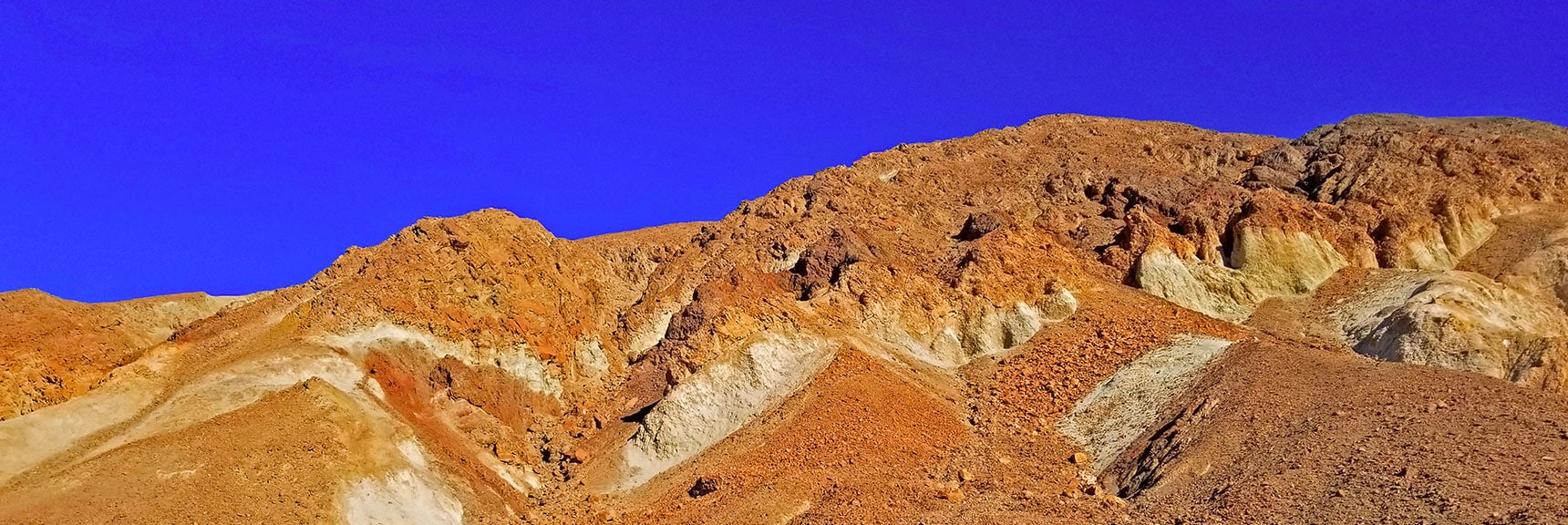 Colors in the Hills Above Indicate Various Minerals: Red is Iron, White is Manganese, Green is Copper. | Golden Canyon to Zabriskie Point | Death Valley National Park, California