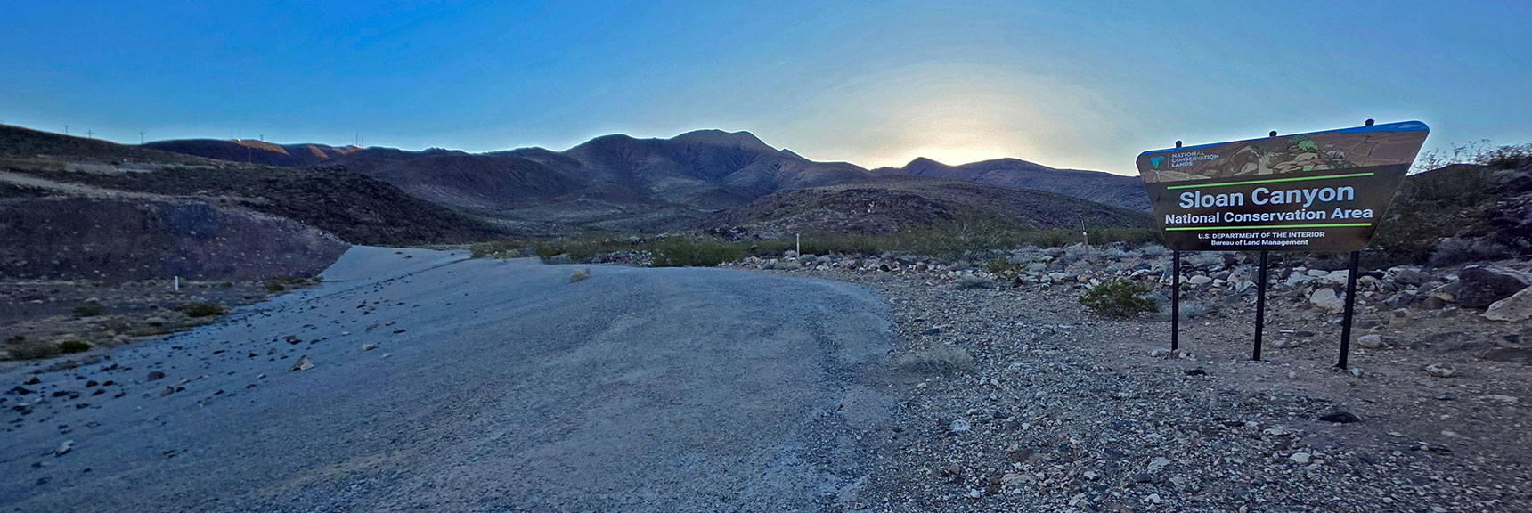 Pass the Sloan Canyon Entrance Sign Along a Huge Flood Retention Basin. | Black Mountain North Loop | McCullough Hills | Sloan Canyon National Conservation Area, Nevada