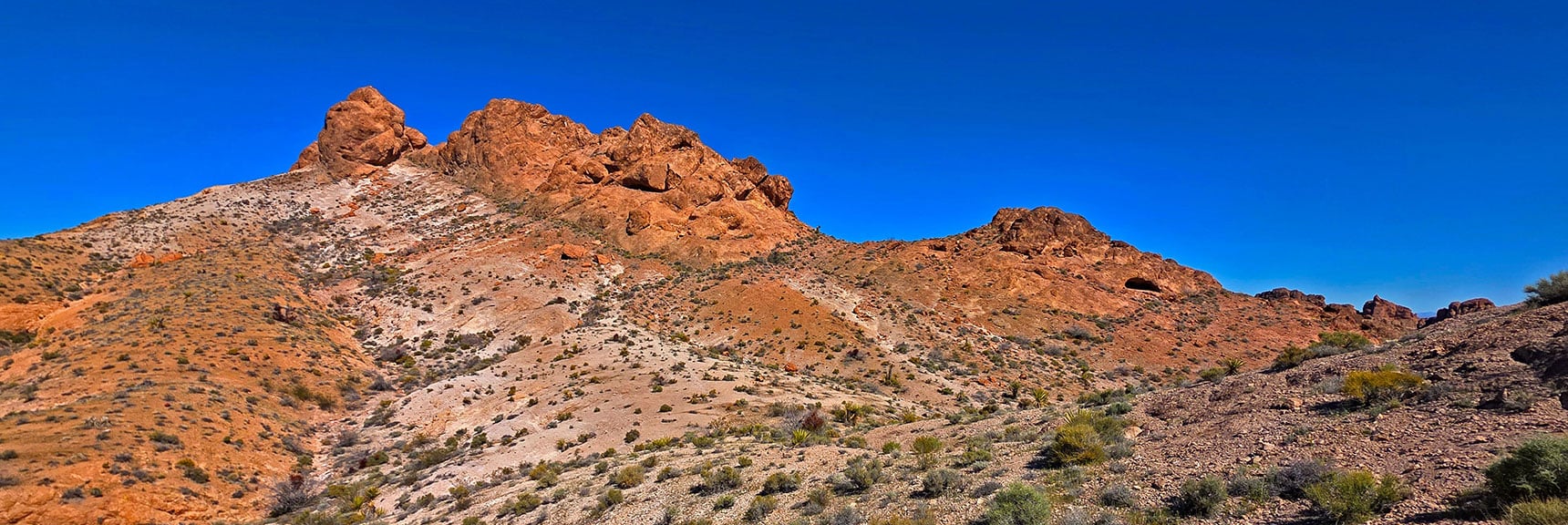 Arrival at the Southern Pig (S End of Pigs in Zen Peak). Passage is Below Cave. | Murl Emery Arch | Eldorado Wilderness, Nevada